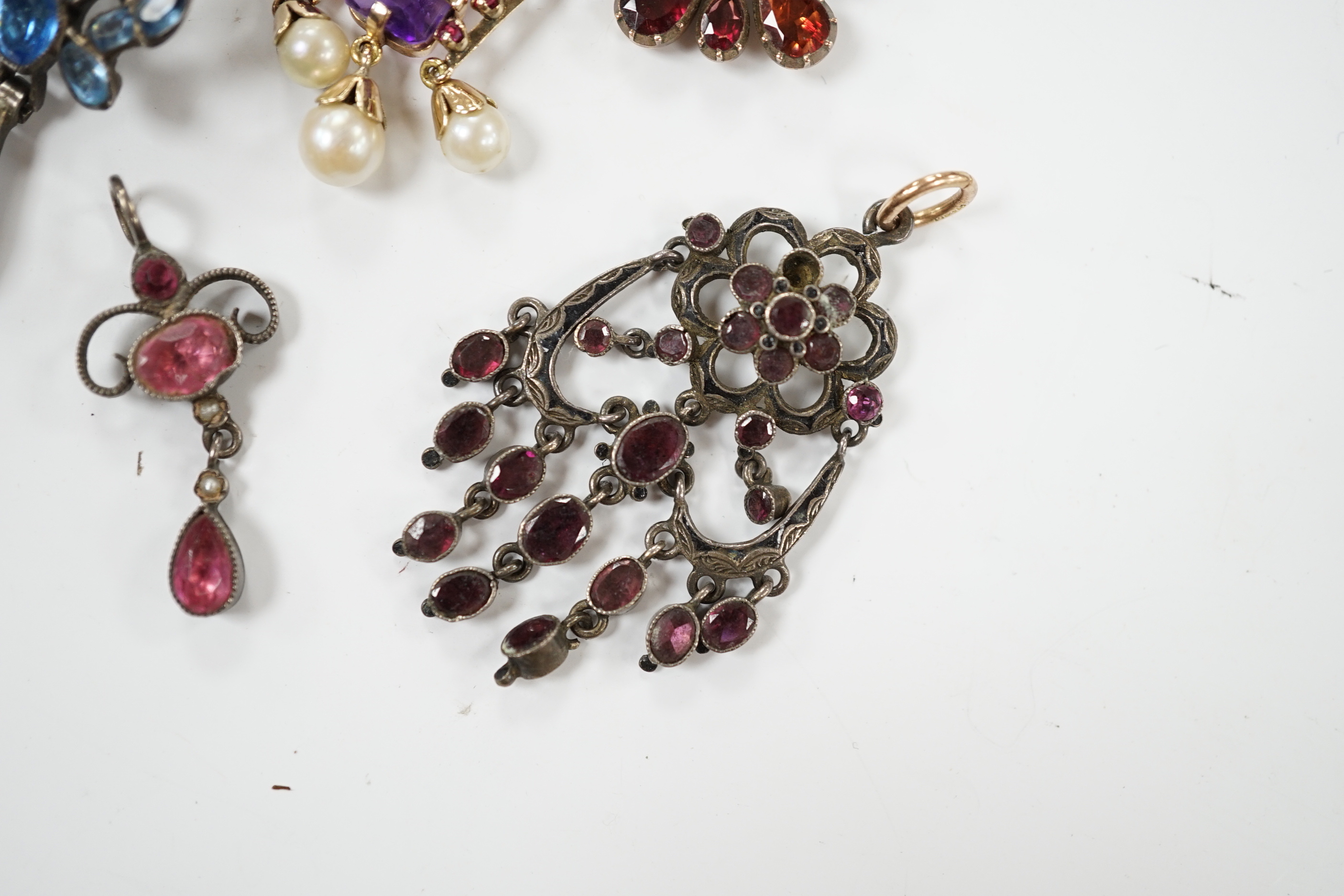 A Georgian yellow metal and foil backed garnet set cluster pendant, 26mm and four other later pendants.